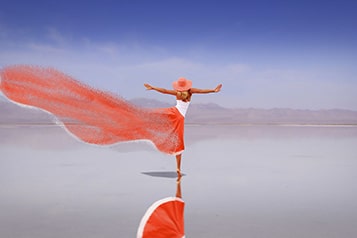 Frau mit rotem Kleid in Salzwüste